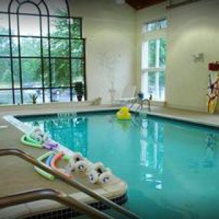 An inviting indoor swimming pool with floaties and natural light.
