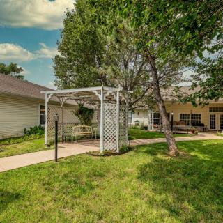 A serene garden with a white gazebo and lush greenery.