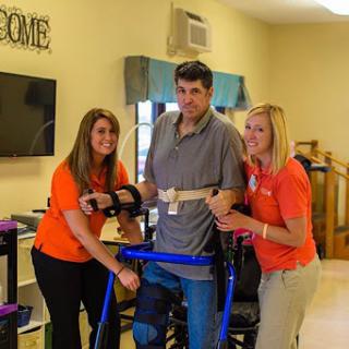 A moment of progress in rehabilitation, showcasing the support from dedicated staff.