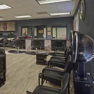 A modern hair salon interior with chairs, mirrors, and hair dryers.