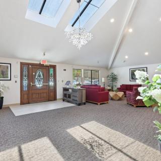 A spacious living room with skylights, elegant chandelier, and comfortable seating.