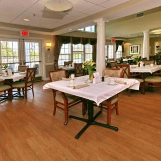A spacious and elegantly decorated restaurant dining area with neatly arranged tables and chairs.