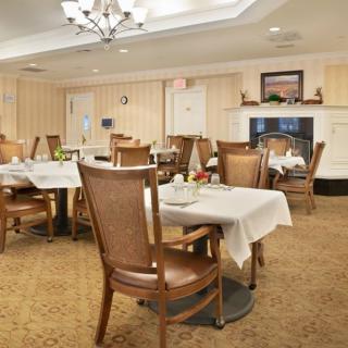 A cozy dining room with elegantly set tables and wooden chairs.