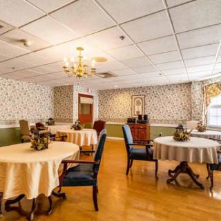 A cozy dining area featuring tables with tablecloths, elegant chairs, and decorative elements.