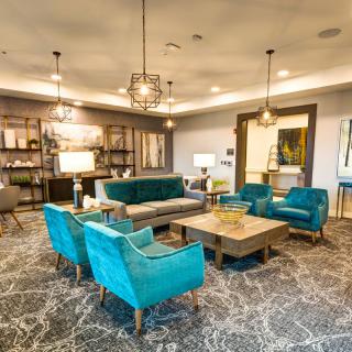 A modern living room with teal seating and chic decor.