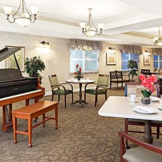A cozy dining area with a piano and elegant decor.