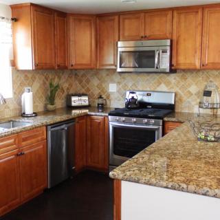 A modern kitchen with wooden cabinets and stainless steel appliances.