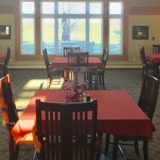 Sunlit dining area with neatly arranged tables and chairs.