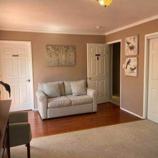 A cozy living room with a beige sofa and decorative wall art.