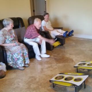 A group of elderly individuals enjoying a game in a comfortable indoor setting.