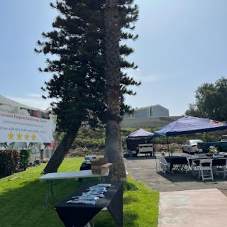 An outdoor event setup with tables and tents under a clear blue sky.