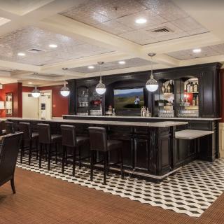A modern bar area with seating and stylish lighting.