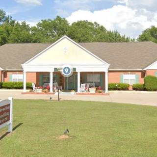 A brick healthcare clinic with a well-maintained lawn.