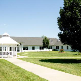 A sunny day at a facility with a gazebo, pathway, and surrounding greenery.