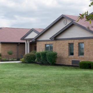 A suburban brick house with a well-maintained lawn.