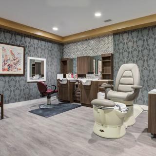 A modern spa and salon room featuring a pedicure chair and hair salon station.