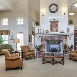 A spacious living room featuring comfortable seating, a brick fireplace, and elegant decor.