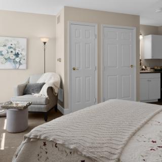 A cozy, modern bedroom with a comfortable bed and armchair.