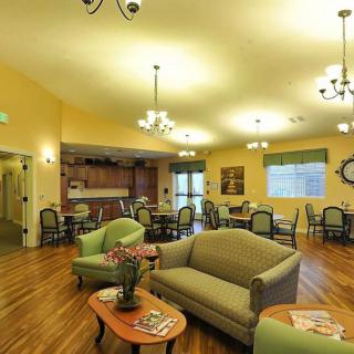 A welcoming living room with comfortable seating, wooden flooring, and elegant chandeliers.