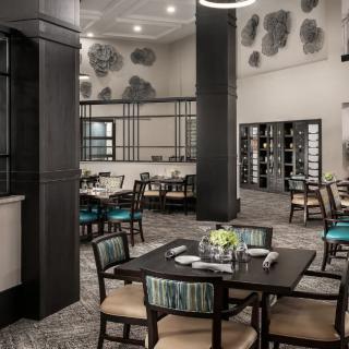 A modern restaurant interior with neatly arranged tables and ambient lighting.