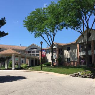 A view of a residential complex featuring well-maintained landscaping and a clear blue sky.