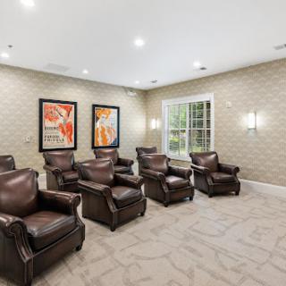 A cozy waiting area featuring plush leather chairs and artistic decor.