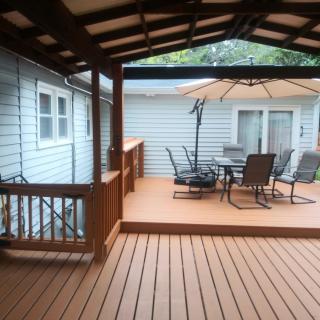 A spacious backyard deck with outdoor furniture and a covered area.