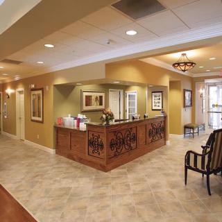 A well-lit office lobby with a reception desk and seating area.