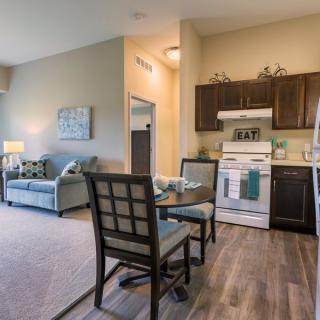 A modern apartment living space featuring an open kitchen and dining area.