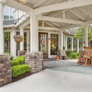 A welcoming house entrance with a covered porch and rocking chair.