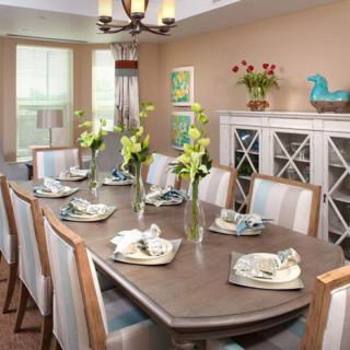 A beautifully set dining room with elegant place settings and floral arrangements.