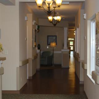 A well-lit hallway with a chandelier and interior furnishings.