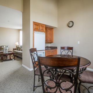 A cozy dining area with a wooden table and chairs adjacent to a compact kitchen.