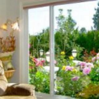 A cozy living room with a large window overlooking a colorful garden.