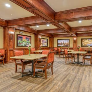 An elegant dining room with wooden interiors and decorative paintings.