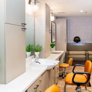 Modern salon interior with bright chairs and elegant lighting.