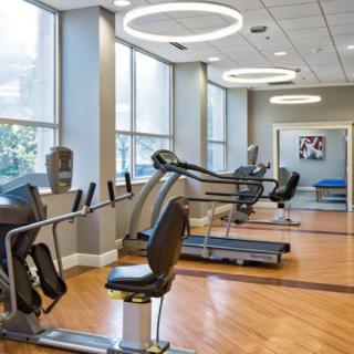A modern gym with exercise equipment including treadmills and stationary bikes.
