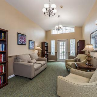 A cozy living room with sofas, bookshelves, and elegant lighting.