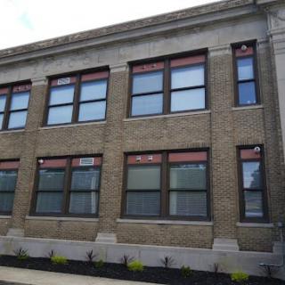 A two-story brick building with large windows and classical architectural details.
