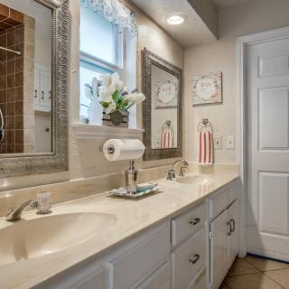 A modern bathroom featuring a double sink with a large mirror and decorative elements.