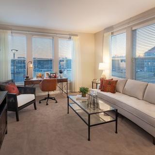 A modern living room with a comfortable sofa, large windows, and well-placed furniture.