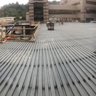 A view of a construction site rooftop featuring steel beams and scaffolding.