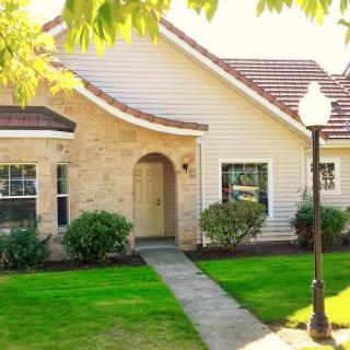A charming house with a well-maintained lawn and a lamp post by the pathway.