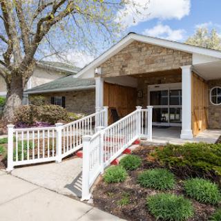 A welcoming entrance featuring a ramp for accessibility, surrounded by well-maintained landscaping.