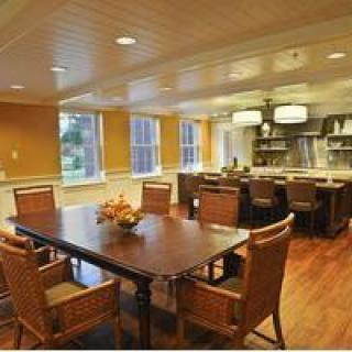A cozy dining area with a wooden table, chairs, and an open kitchen layout.
