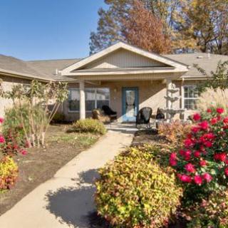 A welcoming home entrance with a well-maintained garden and blooming flowers lining the pathway.