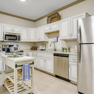 A modern kitchen featuring stainless steel appliances and white cabinets, complete with a central island.