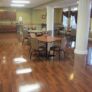 A dining area with tables and chairs on a hardwood floor.