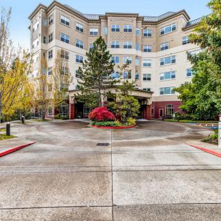 A residential building with a landscaped entrance and driveway.