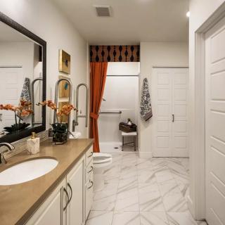 A modern bathroom with double sinks and a marble floor.